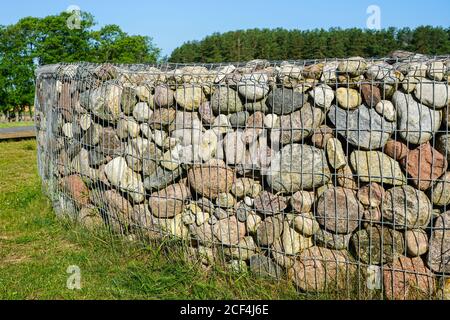 gabion fence wall from steel mesh with stones Stock Photo
