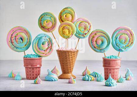 Colorful meringue lollipop in ceramic cone. Closeup with copy space Stock Photo