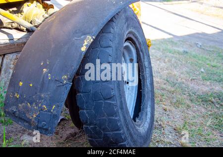 Old rusty tractor's flat back tire. industrial Stock Photo