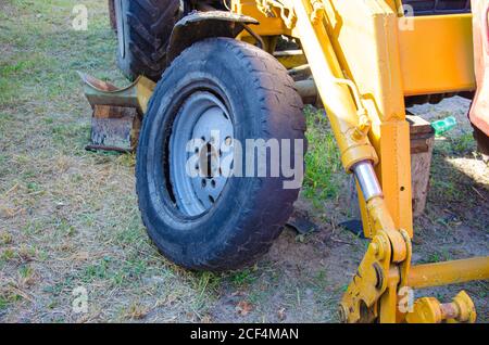 Old rusty tractor's flat back tire. industrial Stock Photo