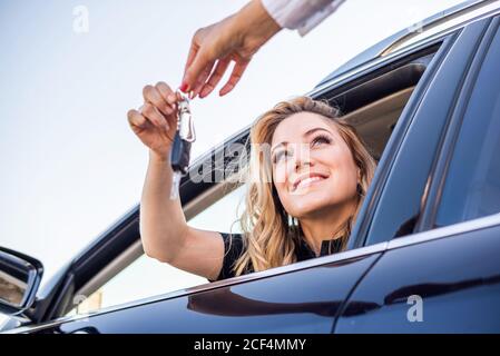 Beautiful woman gets the key from the car Stock Photo
