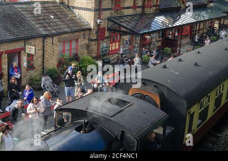 Day-trippers to the Lake District wait on a platform at Haverthwaite Railway Station to board a steam train excursion to the Lakeside in Cumbria UK Stock Photo