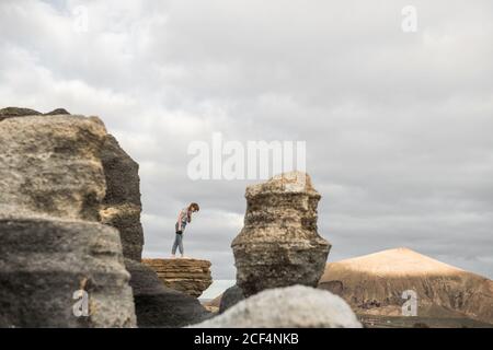 anonymous female taking pictures of stony terrain Stock Photo