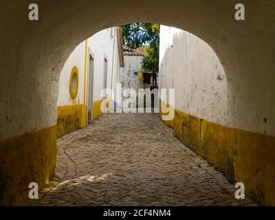 Street and alley with white and yellow painted walls at Óbidos Village in Estremadura Province - Portugal. Stock Photo
