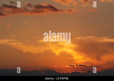 Fiery orange sunset sky. Beautiful colors and clouds. Stock Photo