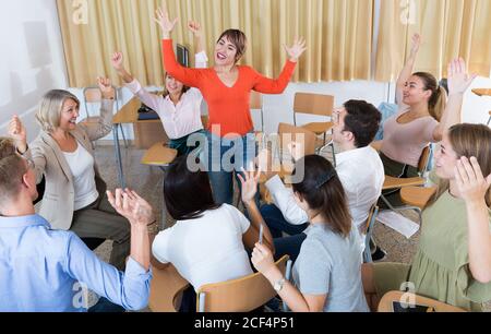 Portrait of delighted girl student with her groupmates and female teacher in university auditorium Stock Photo