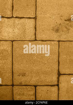 Vertical background with geometric pattern of highly detailed street pavement made of various square blocks. Textured rough surface toned in honey dij Stock Photo