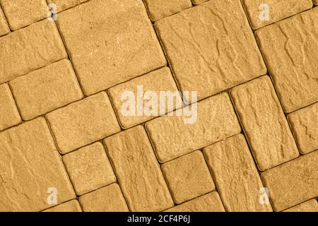 Highly detailed street pavement background with diagonal geometric pattern made of various square blocks with textured rough surface toned in honey di Stock Photo