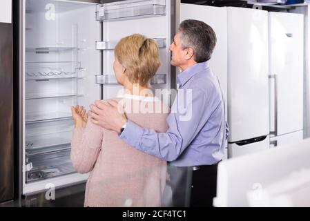 Mature couple  chooses refrigerator in store of household appliances Stock Photo