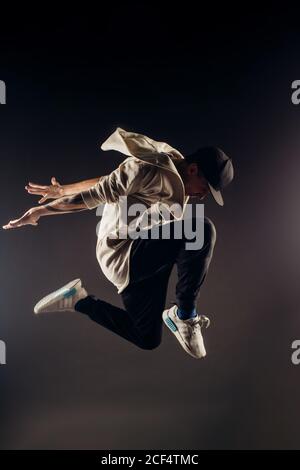 Jumping young male dancer on grey background Stock Photo