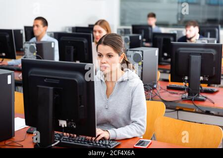Diligent friendly smiling  teacher conducts computer science exam in university class Stock Photo