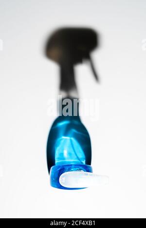 Top view of transparent bottle with blue soap liquid reflecting glowing crystal shadows on white surface Stock Photo