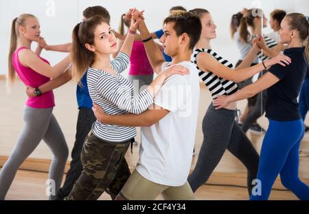 Group of positive french teen dancing salsa in dance studio Stock Photo