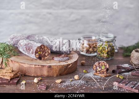 Chocolate salami with nuts on wooden table Stock Photo