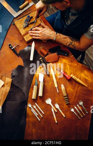 Crafting tools on natural cow leather in the tailoring workshop. Top view. Stock Photo