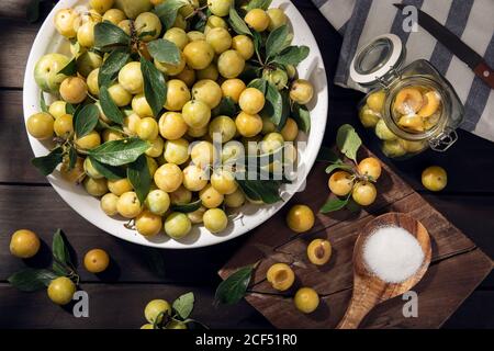 Fresh Yellow plum mirabelle fruit in bowl on wooden table. Preparing plum marmalade Stock Photo