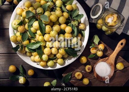 Fresh Yellow plum mirabelle fruit in bowl on wooden table. Preparing plum marmalade Stock Photo