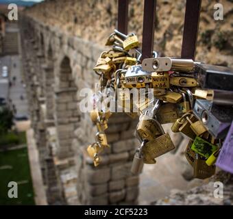 Love locks on the Roman Aqueduct of Segovia,Spain located in Plaza del Azoguejo. Stock Photo