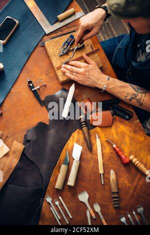 Man working with leather using crafting DIY tools Stock Photo