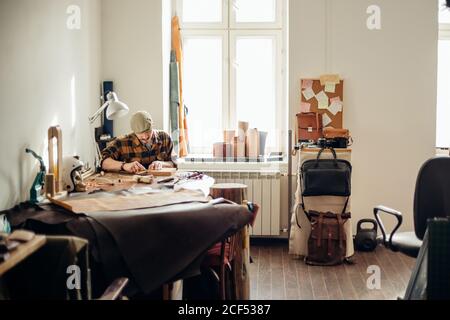 Man working with leather using crafting DIY tools Stock Photo