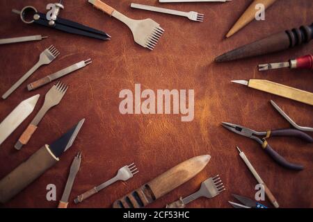 Crafting tools on natural cow leather in the tailoring workshop. Top view. Stock Photo