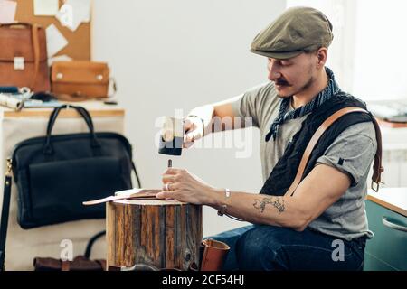 Man working with leather using crafting DIY tools Stock Photo
