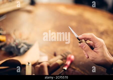 leather craftsman working making products at table in workshop studio Stock Photo