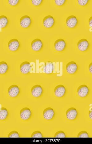 Seamless Easter pattern with colored decorated eggs arranged in rows on yellow background Stock Photo