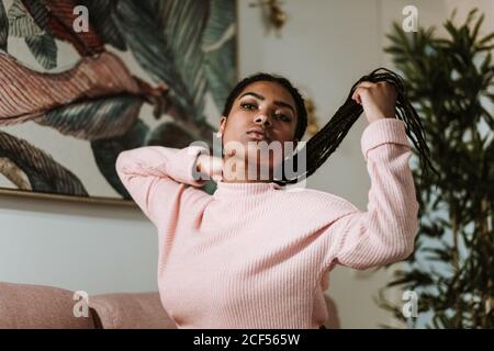 Bored young Woman sitting on sofa Stock Photo