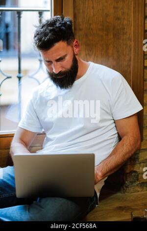 Bearded freelancer using laptop at home Stock Photo