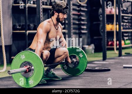 strong and athletic man doing barbell workout in modern gym Stock Photo
