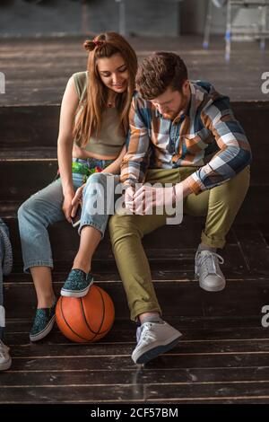 Group of friends having fun at the cafe and looking at smart phone. Man showing something to his friends sitting Stock Photo