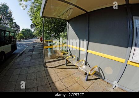 A bus stop and passing bus in Greater Manchester Stock Photo