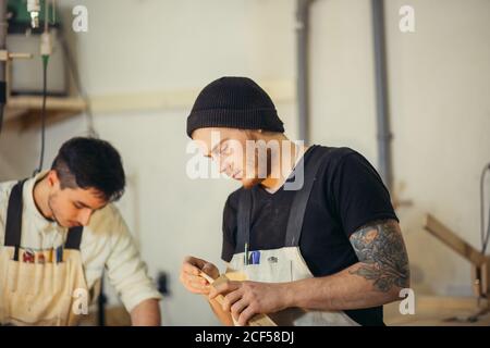 Man doing woodwork in carpentry. Carpenter work on wood plank in workshop Stock Photo