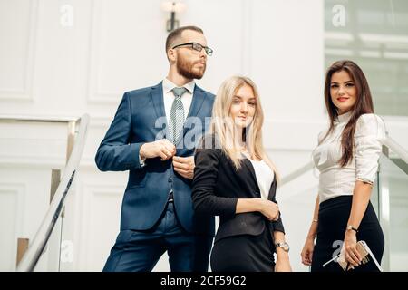 two businesswoman and businessman posing in office Stock Photo