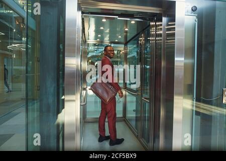 Business man exit on elevator. Business people in a large glass elevator in a modern office Stock Photo