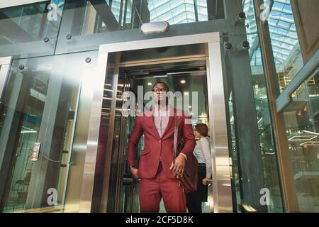 business group comes out from glass Elevator Stock Photo