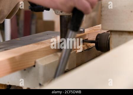 Crop man using special electric machine while working in contemporary workshop Stock Photo