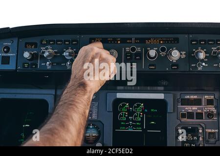 Crop anonymous male pilot using keyboard of flight management system in ...