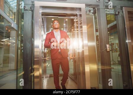 business group comes out from glass Elevator Stock Photo
