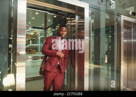 business group comes out from glass Elevator Stock Photo