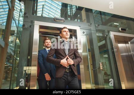 business group comes out from glass Elevator Stock Photo