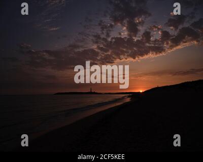 Beautiful sunset over sea with cloudy sky on a beach in the seashore Stock Photo