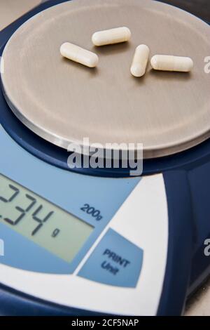 https://l450v.alamy.com/450v/2cf5nap/weighing-of-capsules-and-pills-in-precision-scales-of-medicine-and-liquid-pharmaceutical-products-in-laboratory-2cf5nap.jpg