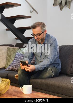 man talking on the phone from the sofa at home relaxed at home Stock Photo