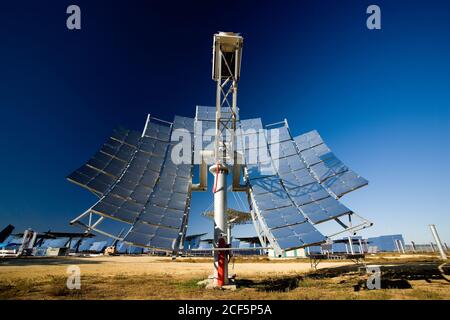 Modern solar panel installed in middle of photovoltaic power station against cloudless blue sky on sunny day in countryside Stock Photo
