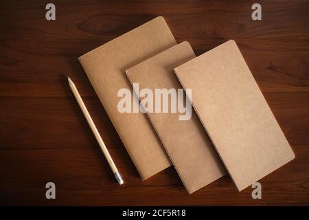 cool traditional notebooks on wooden table and pencil Stock Photo