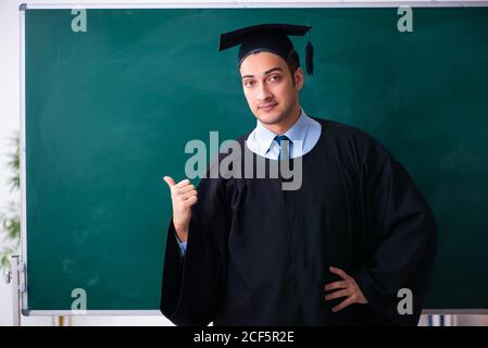 Young male graduate in front of the board Stock Photo
