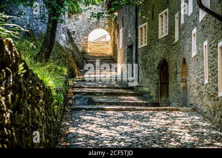Pedestrian alley view of the Valere Basilica with old medieval buildings and paved road in Sion Valais Switzerland Stock Photo
