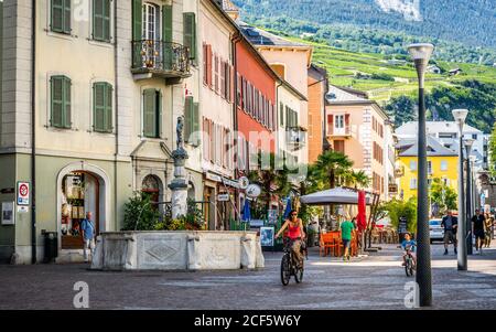 Sion Switzerland , 3 July 2020 : Fountain and people in Sion main pedestrian shopping street called Rue du Grand-Pont of Sion old town Switzerland Stock Photo